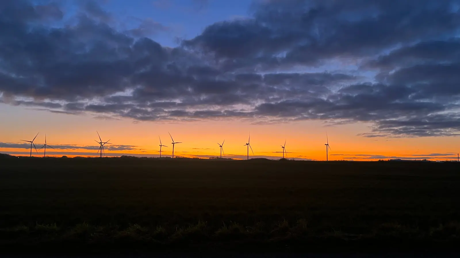 Solnedgang med vindmøller i horisonten